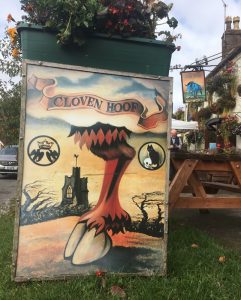 Pub sign The Cloven Hoof on the grass outside The Blue Boar pub in Aldbourne.